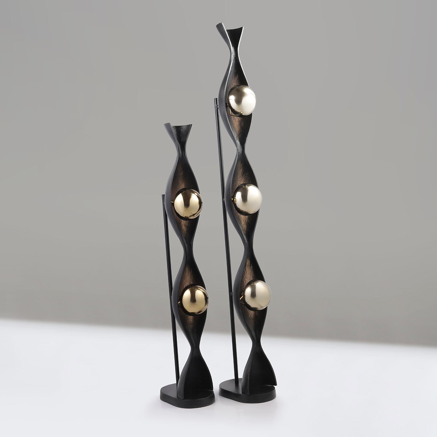 Decorative floor lamps with black and gold design on a neutral background