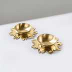 Two gold decorative items with floral designs on a white surface.