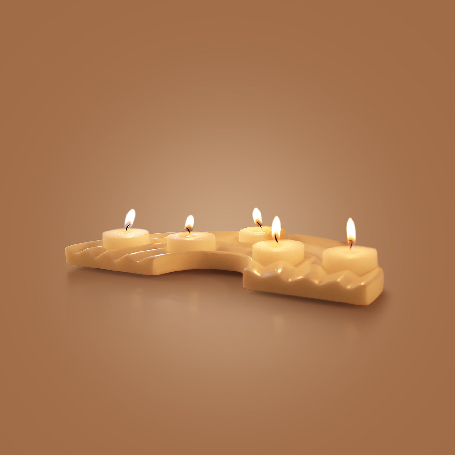 Marble candle holder with four lit candles on a brown background
