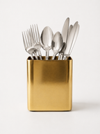 Set of silver cutlery in a gold holder on a white background