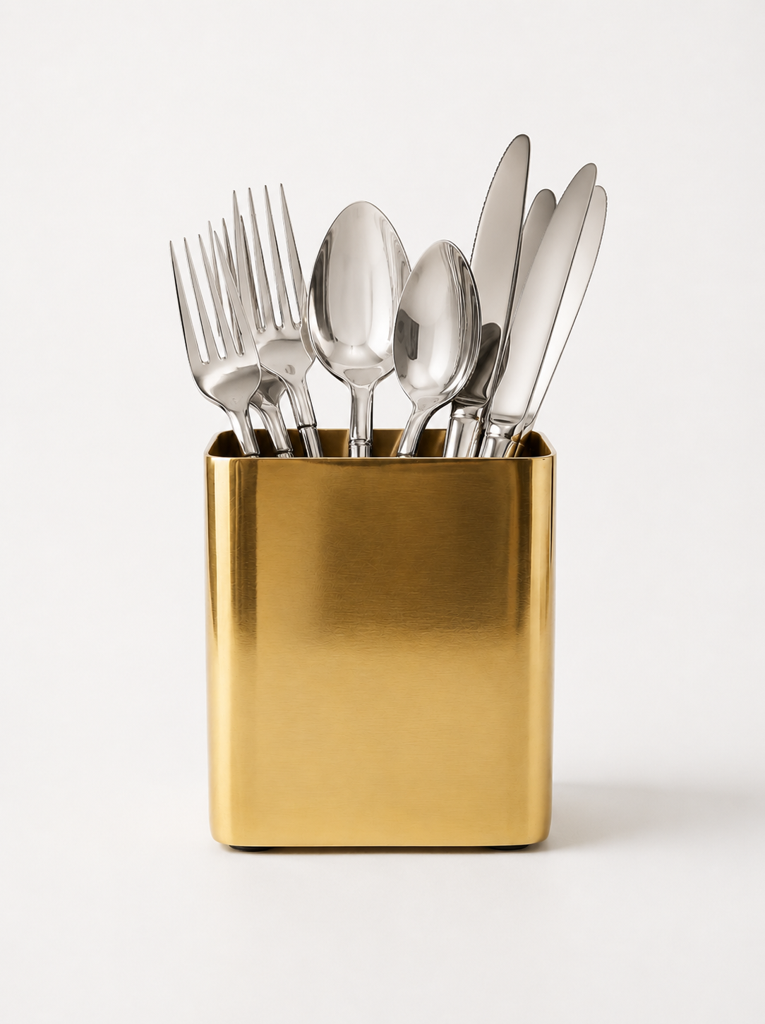 Set of silver cutlery in a gold holder on a white background