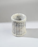 Marble-textured cylindrical container on a light gray background