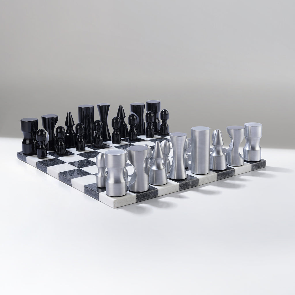 Black and silver chess set on a checkered board against a gray background