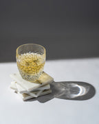 Glass of whiskey on a marble coaster with a dark background