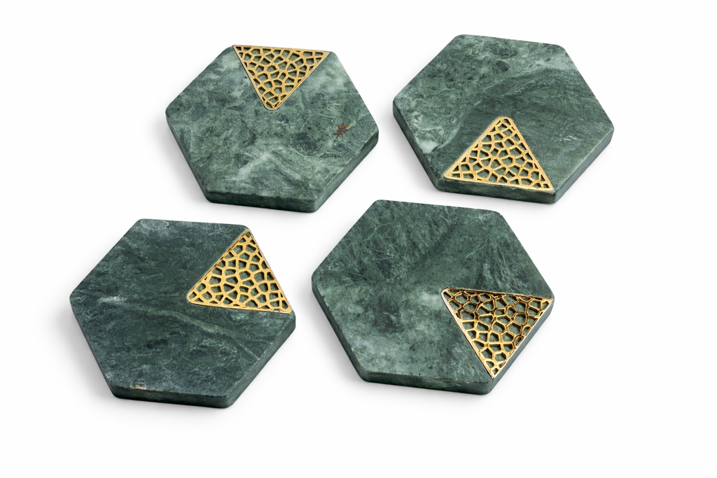 Four hexagonal green marble coasters with gold geometric design