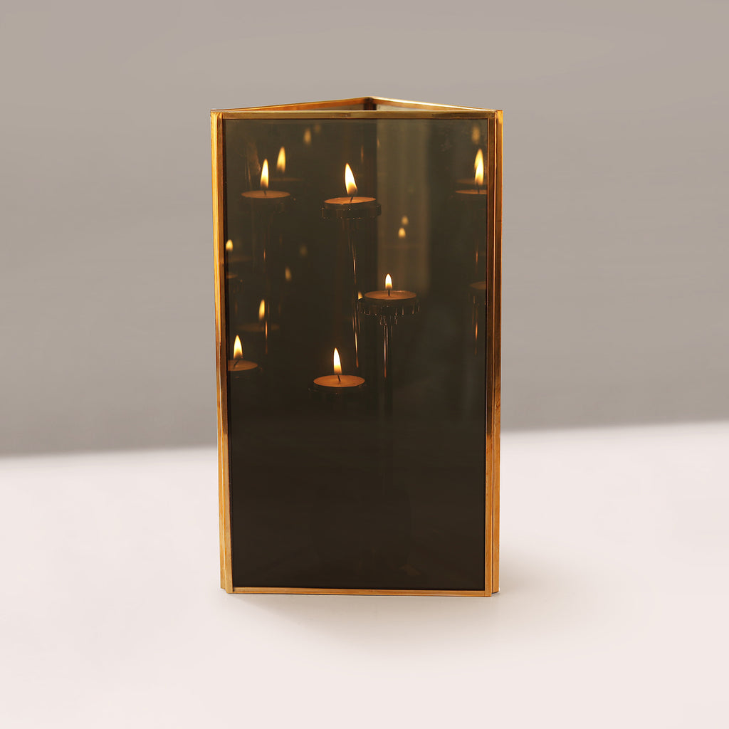 Decorative Lamp with gold frame and candle-like reflections on a neutral background
