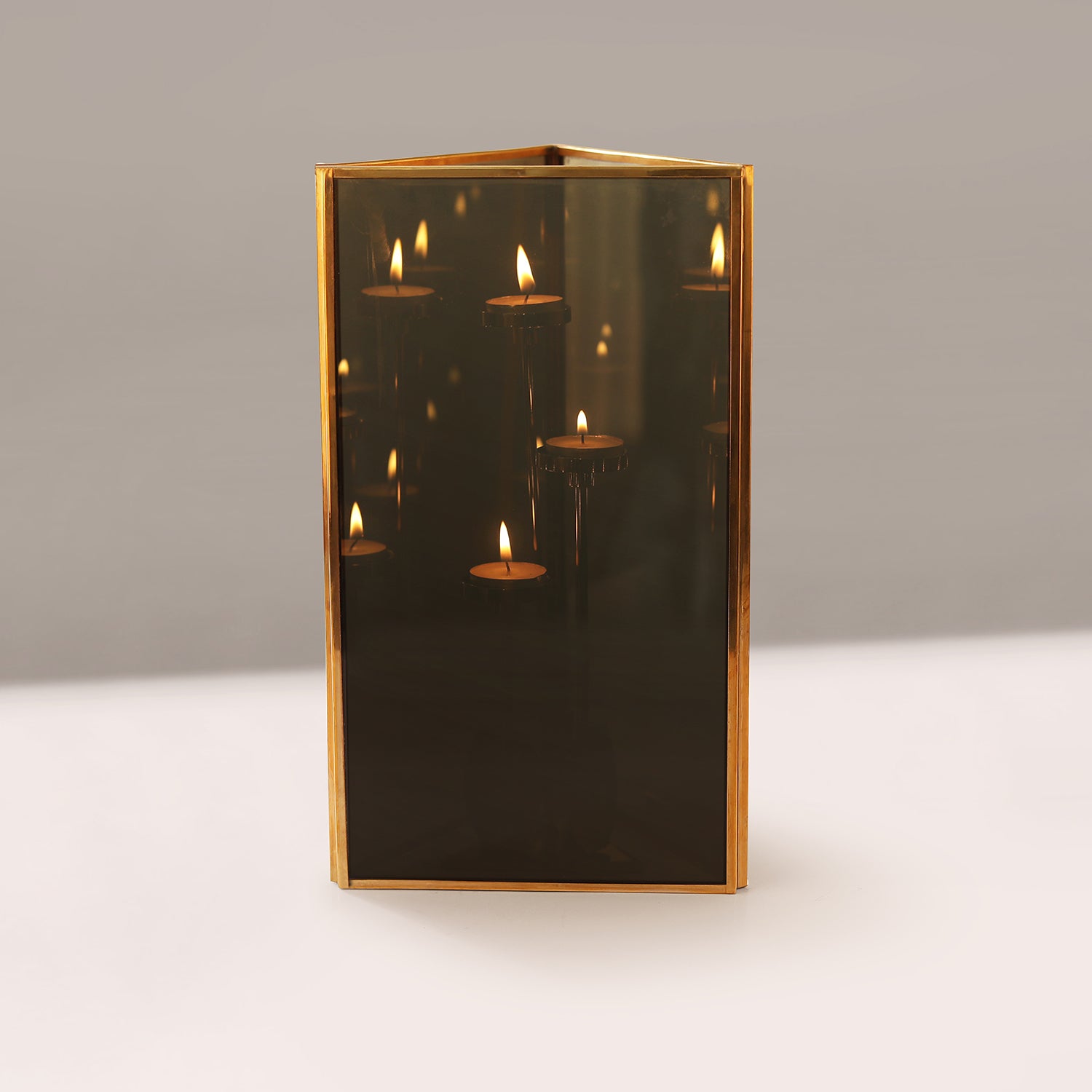 Decorative Lamp with gold frame and candle-like reflections on a neutral background