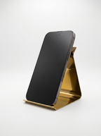 Black smartphone on a gold stand against a white background