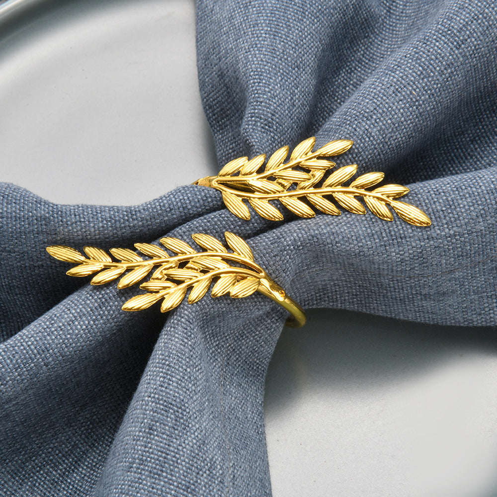 Gold leaf-shaped napkin ring on a gray napkin