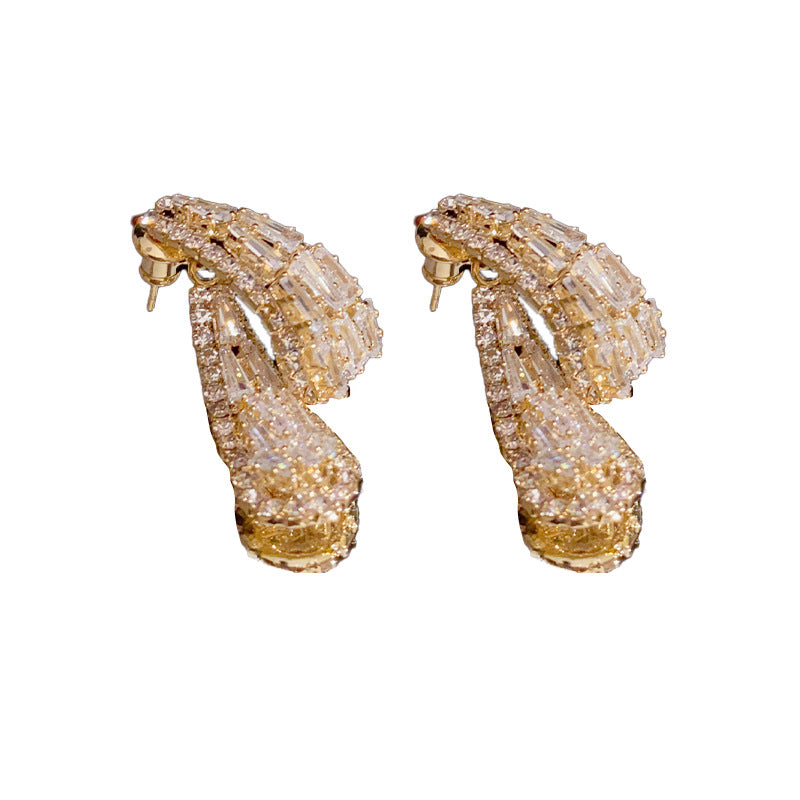 Pair of gold hoop earrings with clear gemstones on a white background