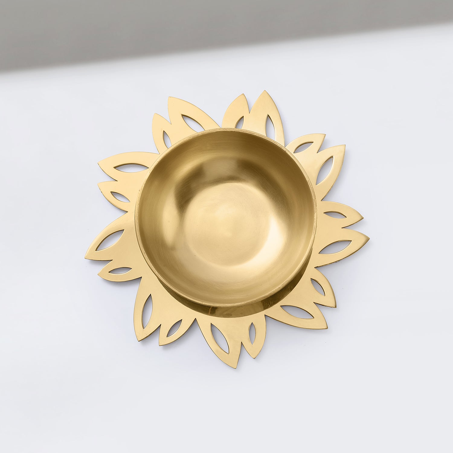 Gold decorative dish with floral patterns on a white background