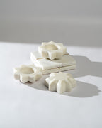 White marble flower-shaped tea lights on a light grey background