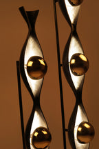 Decorative metal sculpture with gold accents on a brown background