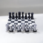 Black and silver chess set on a checkered board