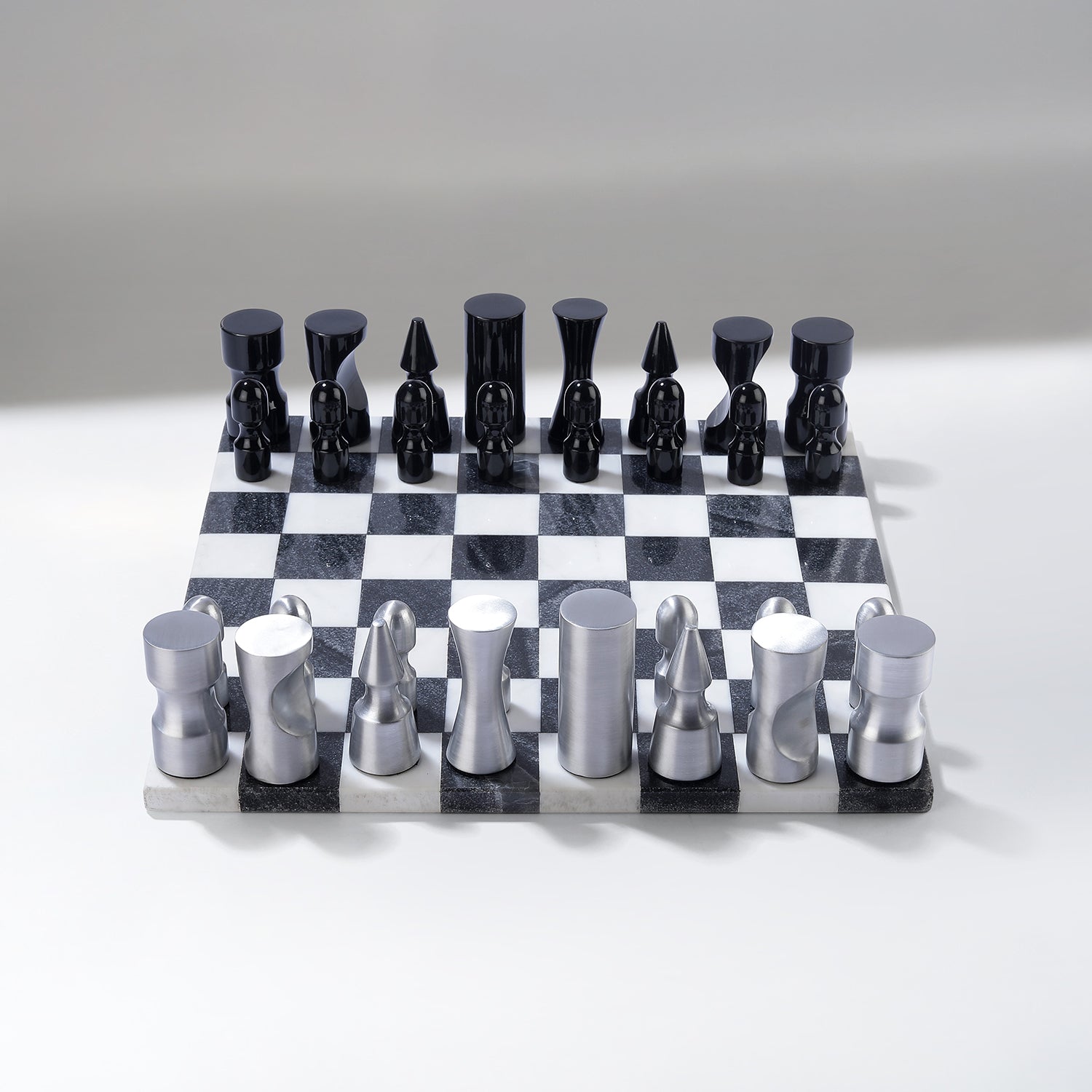 Black and silver chess set on a checkered board