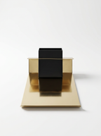 Gold and black geometric sculpture on a white background