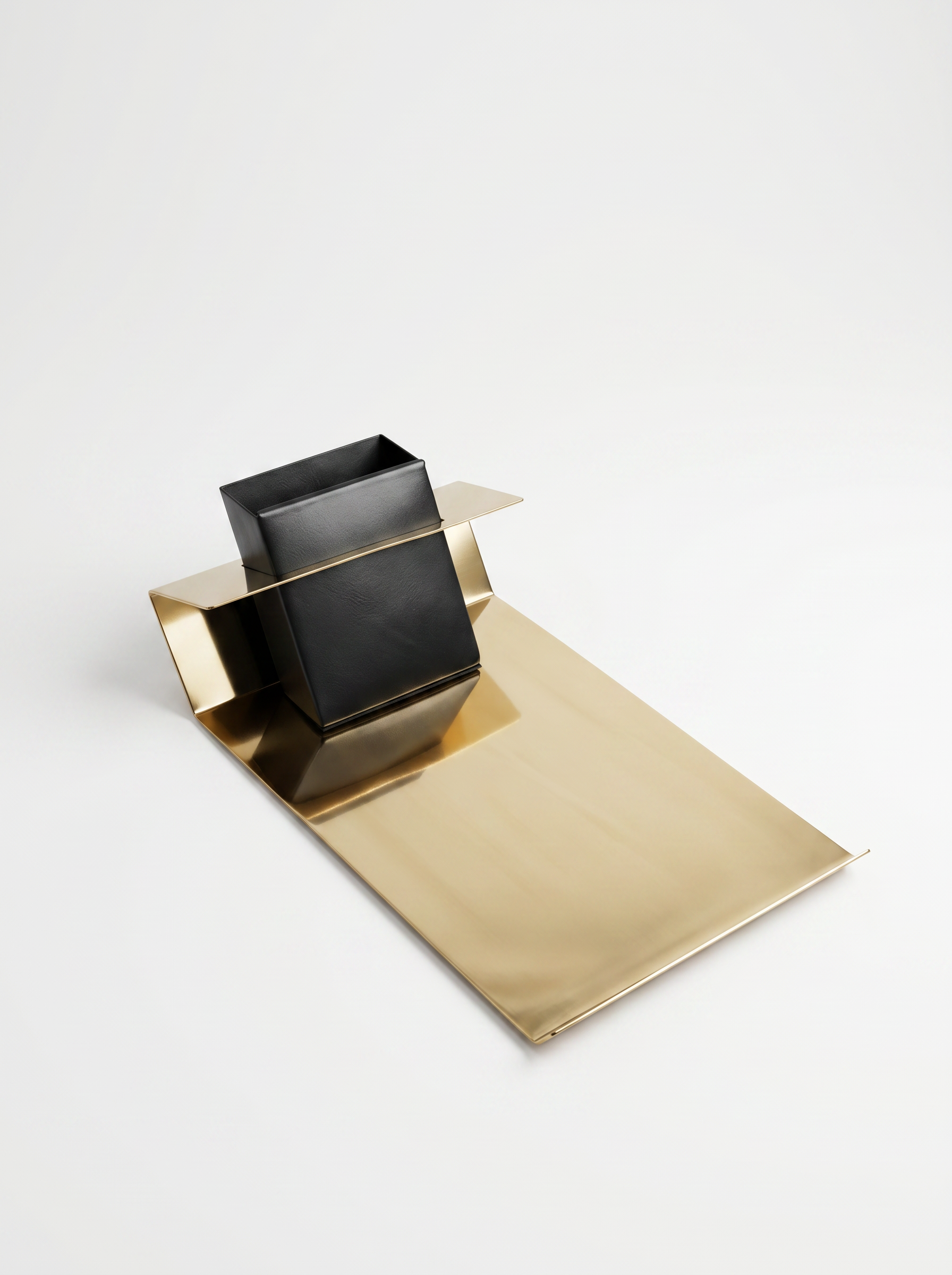 Black cube-shaped Pen stand on a gold stand against a white background