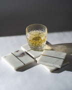 Glass of whiskey on marble coasters with a dark background