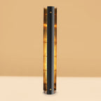 Black cylindrical lamp with a warm glow