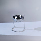 Circular bowl in a slender silver wire stand.