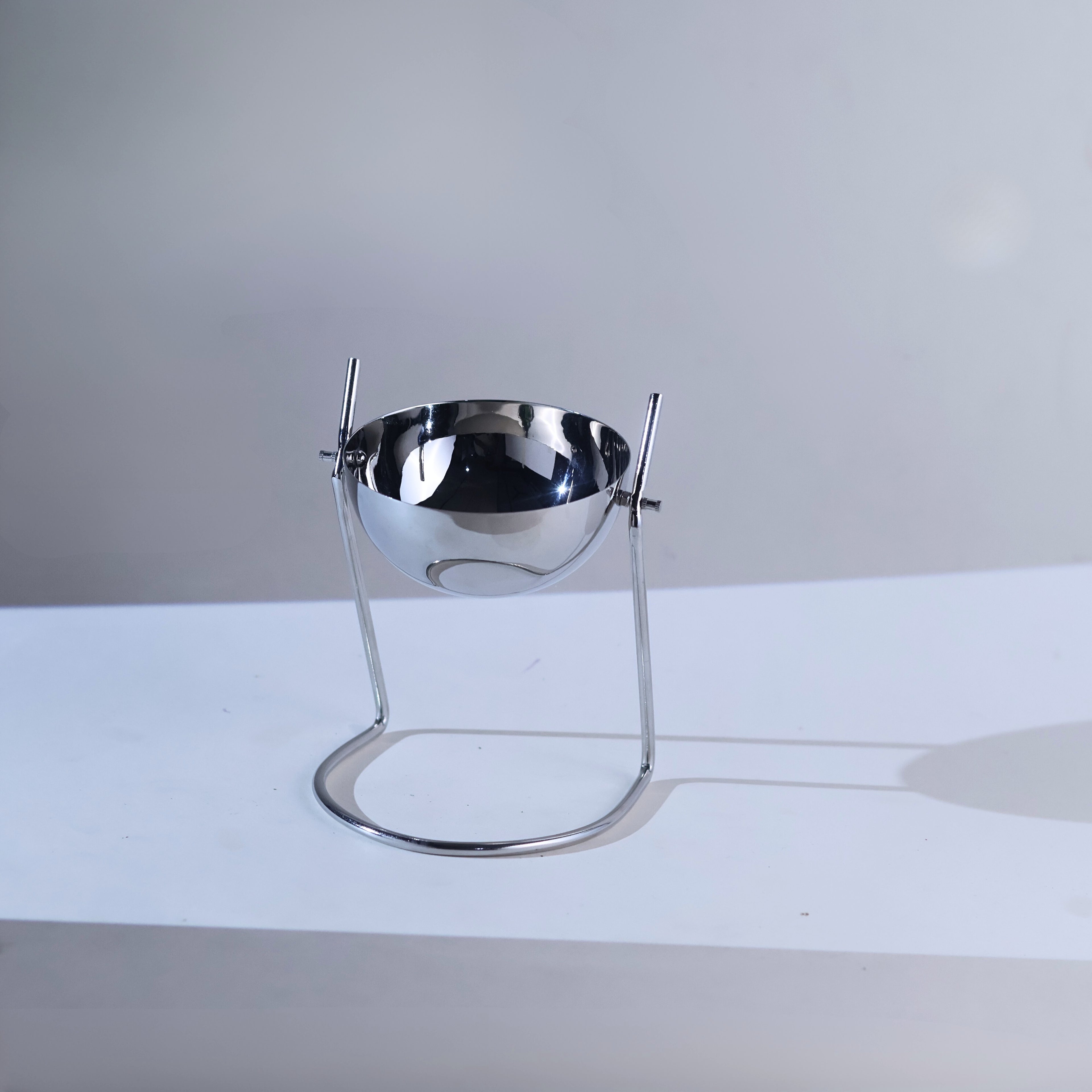 Circular bowl in a slender silver wire stand.