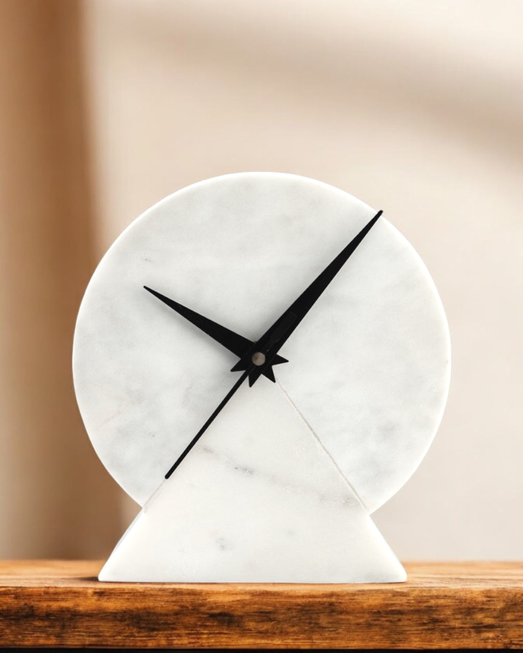 Marble clock with black hands on a wooden surface