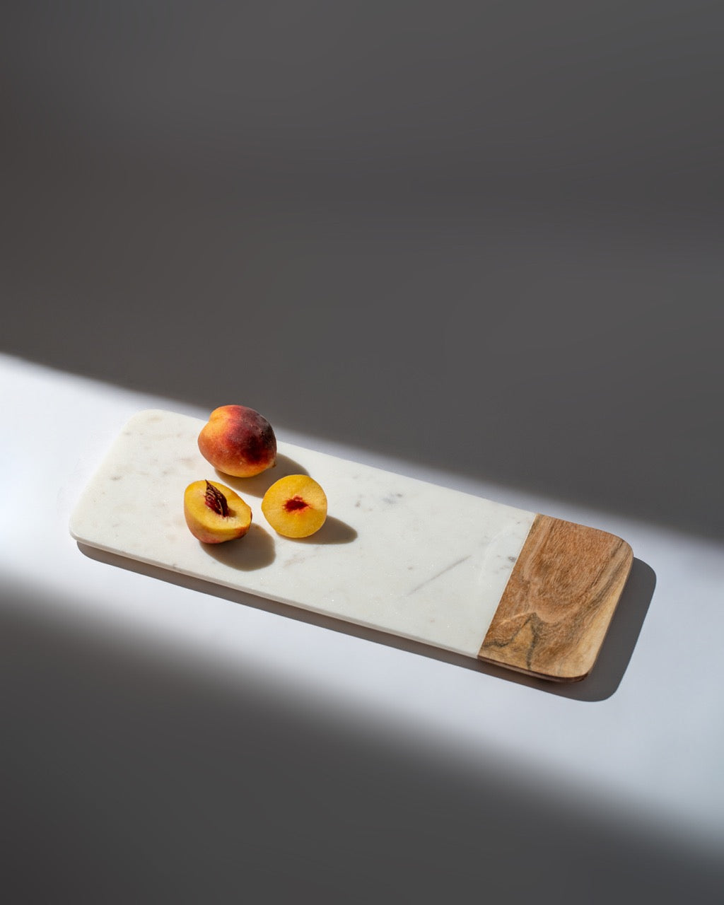 Peaches on a white marble tray.