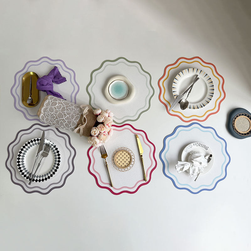 Decorative plates with cutlery and small items on a white placemat